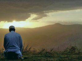 Мужчина совершает намаз в поле