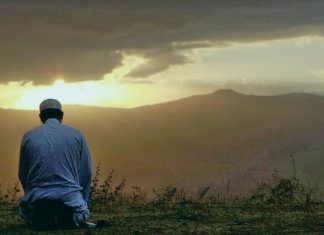 Мужчина совершает намаз в поле